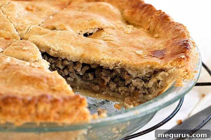 classic tourtiere in pie pan sliced