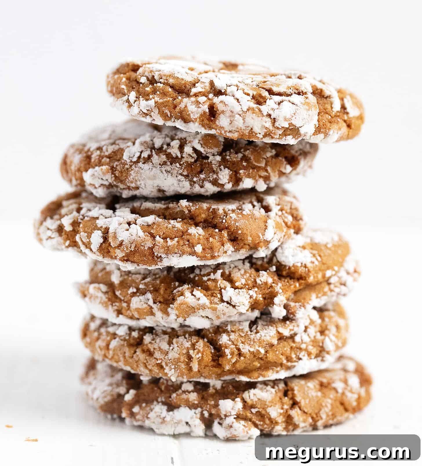 Stack of four ginger crackle cookies, showing the sugary crackle and soft interior.