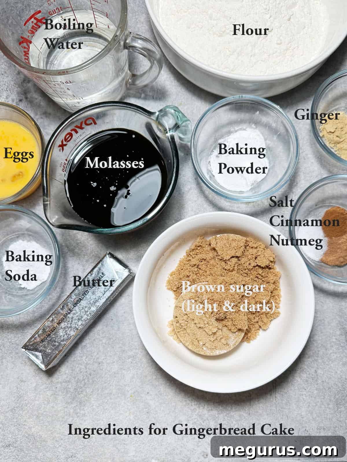 A selection of fresh, high-quality ingredients laid out for baking a classic gingerbread cake, including flour, spices, molasses, and brown sugar.