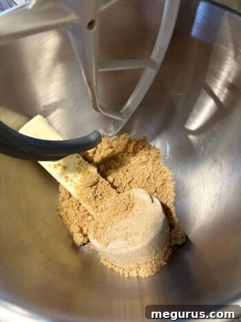 Creaming together softened butter and rich brown sugar in a stand mixer bowl until light and fluffy.