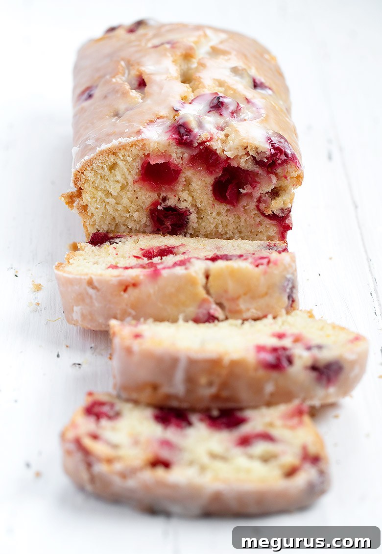 Close-up of cranberry orange loaf with generous glaze, showing the texture and fruit distribution