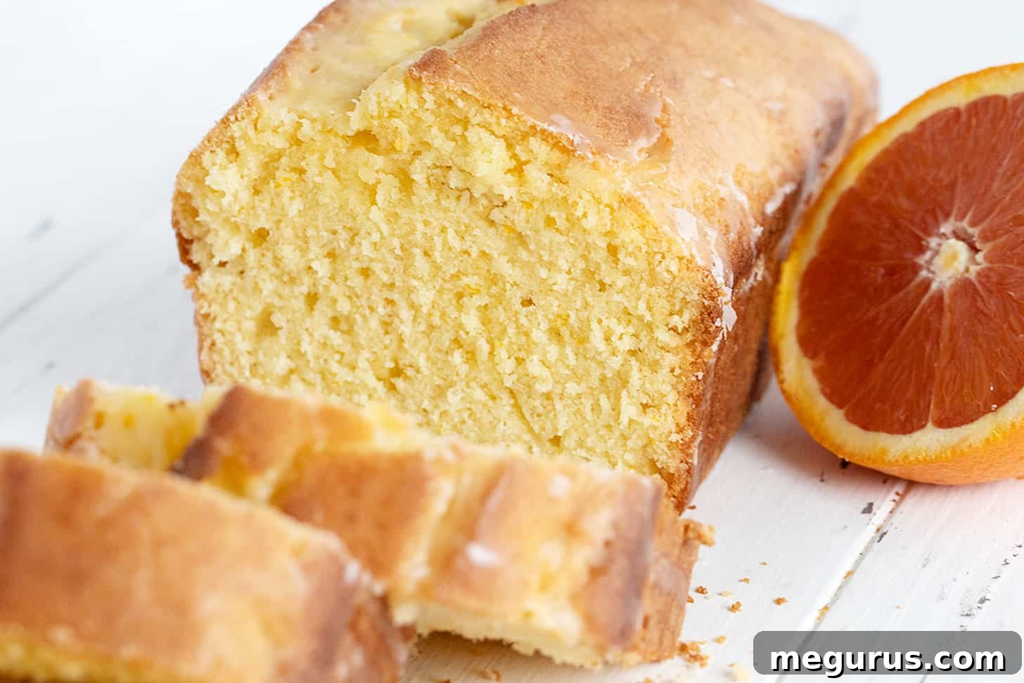 orange pound cake loaf sliced with halved orange