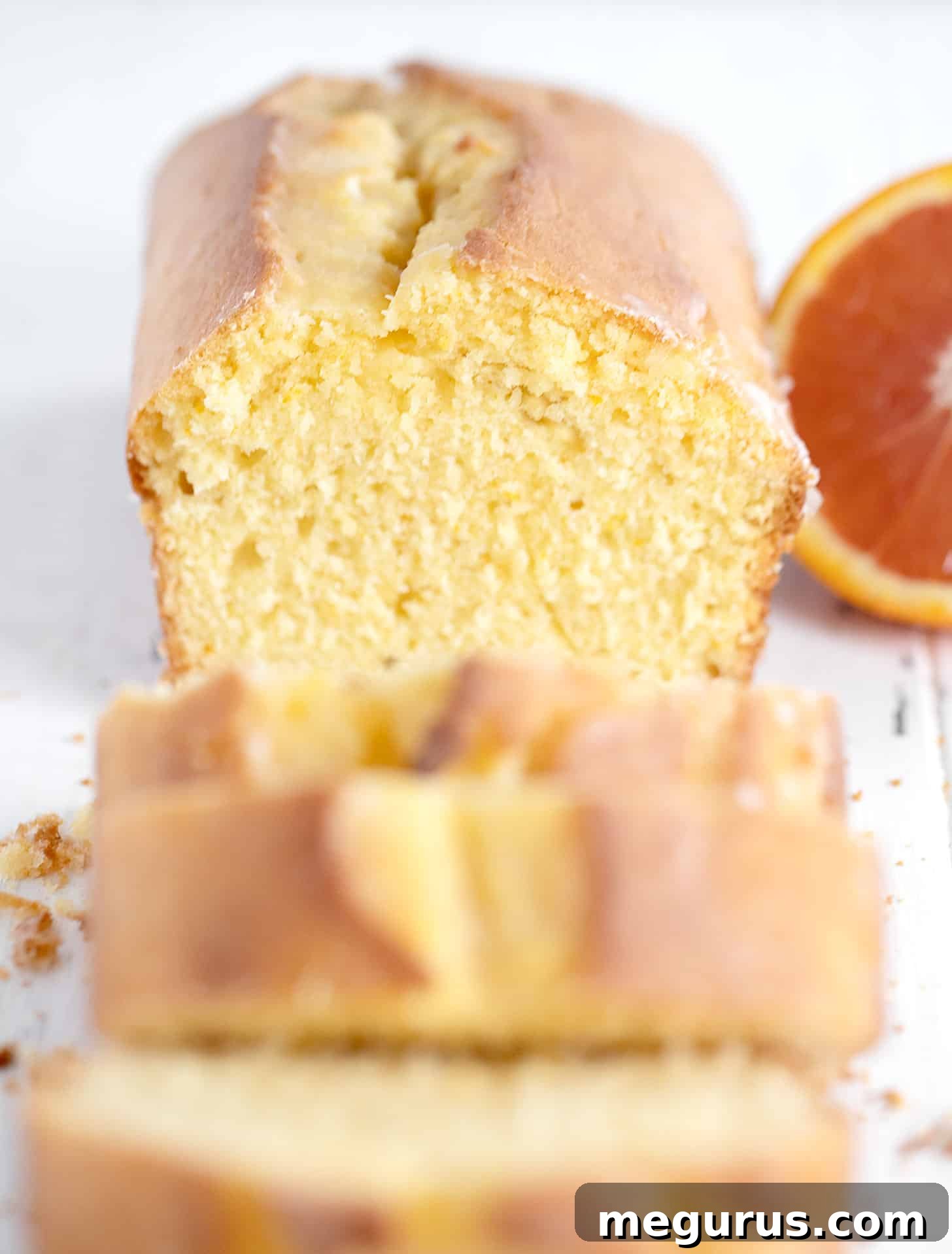 orange pound cake loaf sliced with halved orange