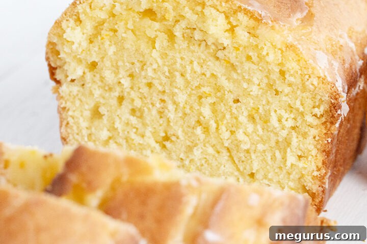orange pound cake loaf sliced with halved orange