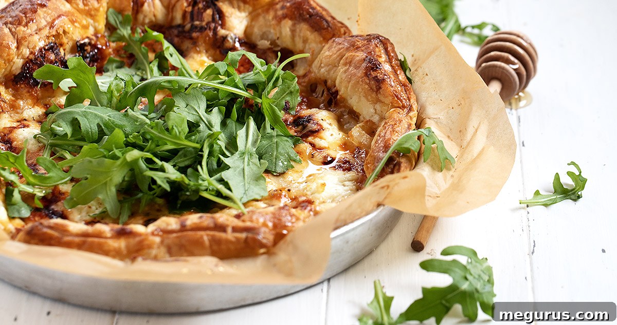 Tarte au chevre topped with arugula and honey, a perfect blend of sweet and savory.