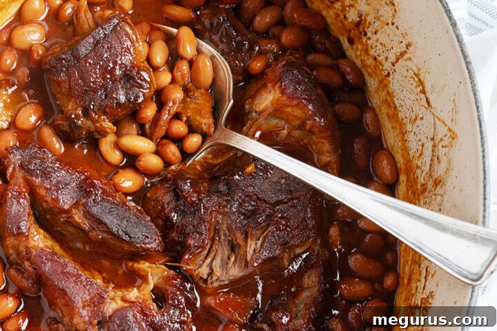 Pork and beans in baking dish with spoon
