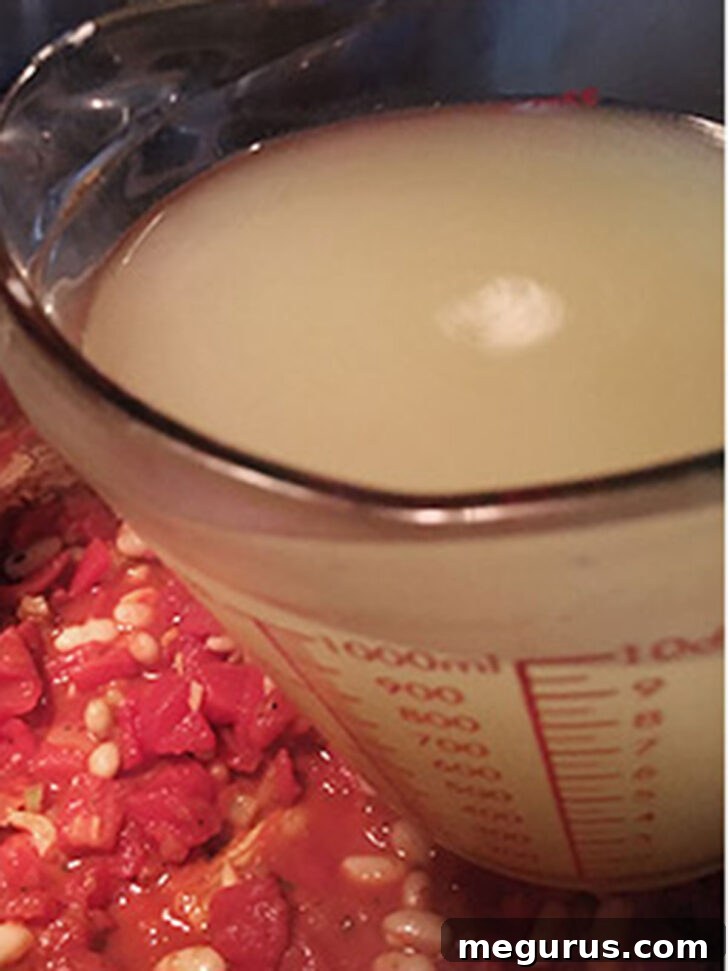 Adding the broth to the pot.