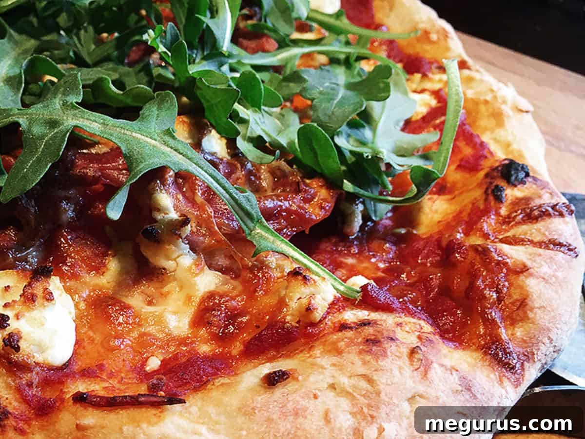 Delicious homemade gourmet pizza on a rustic cutting board with a pizza cutter, ready to be served