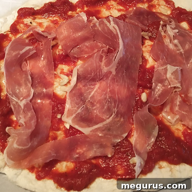 Carefully placing prosciutto and goat cheese toppings onto a fresh homemade pizza crust