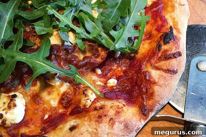 homemade gourmet pizza on cutting board with pizza cutter