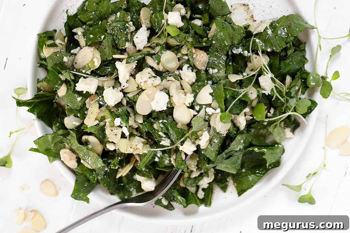 Fresh Feta Almond Salad on a plate with a fork, showcasing crisp romaine, white feta, and golden almonds.