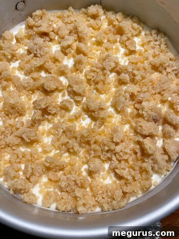Applying the remaining crumb topping to the partially frozen lemon dessert.