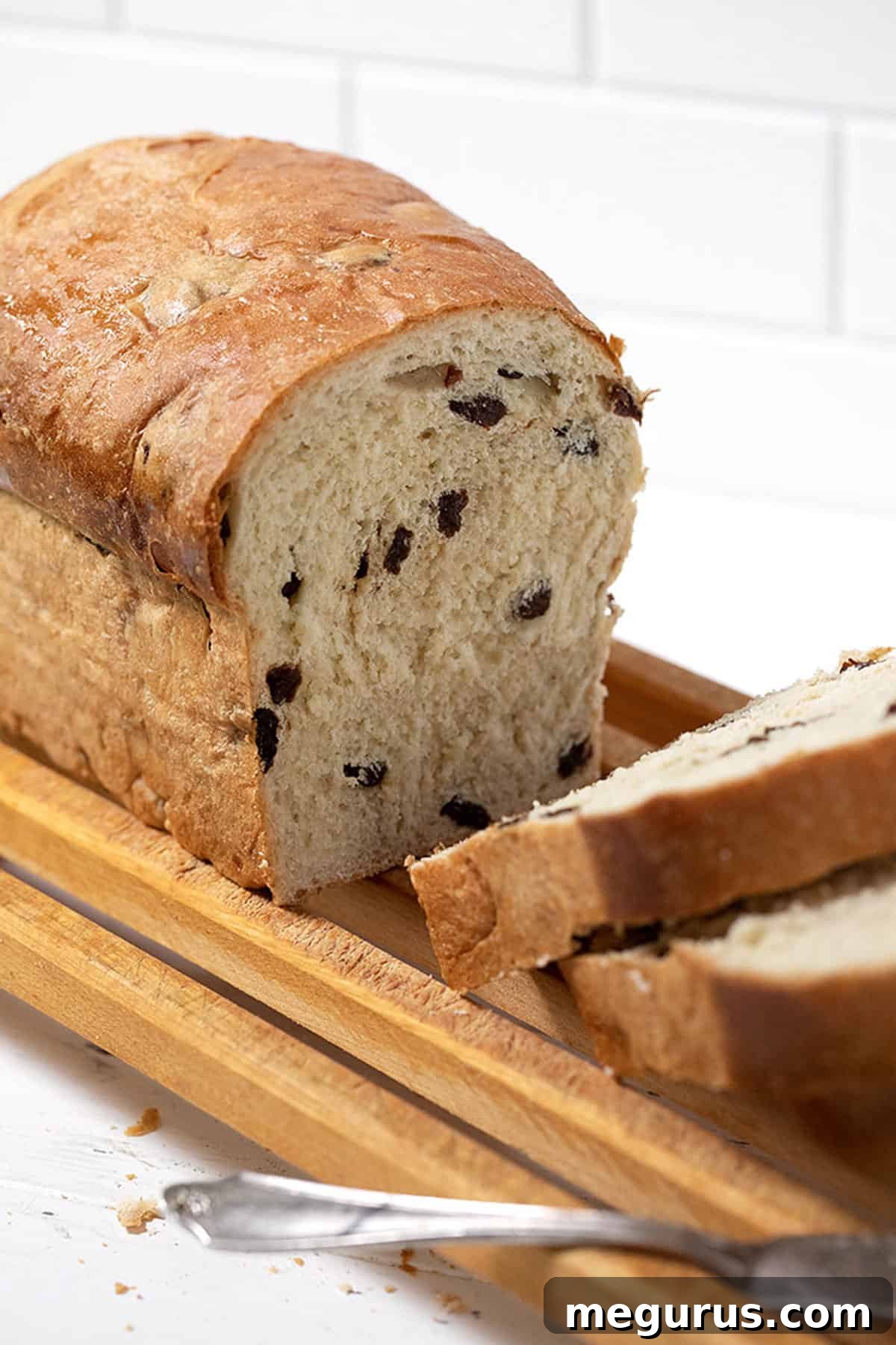 Close-up of freshly baked raisin bread, perfectly sliced to reveal its moist interior and golden crust.