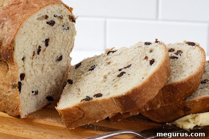 Raisin bread sliced on a cutting rack, showcasing its golden-brown crust and inviting interior.