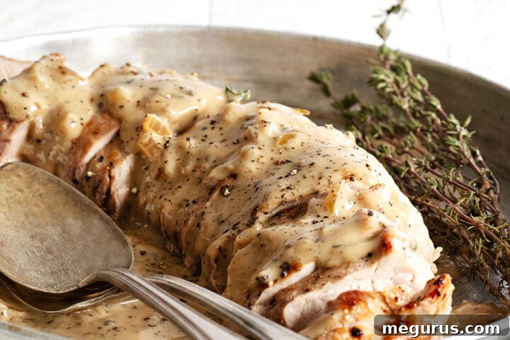 pork tenderloin with peppercorn gravy on platter