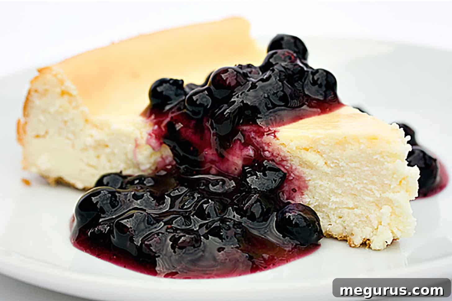 Classic cheesecake topped with luscious homemade blueberry sauce, ready to be served.