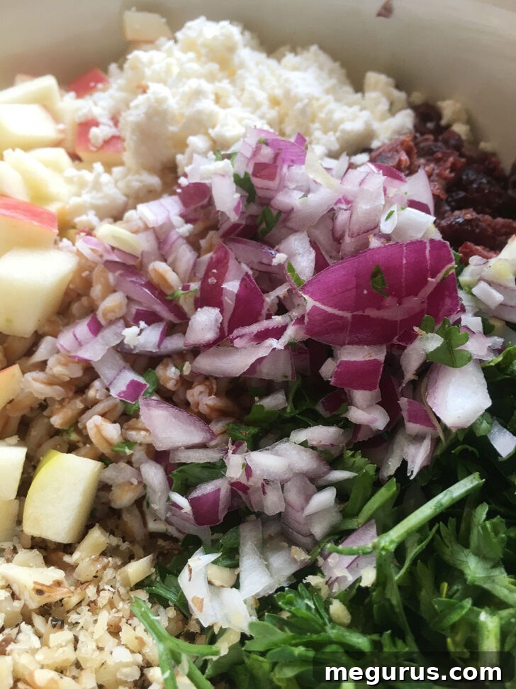 Crumbled feta cheese being added to the salad bowl for a salty, tangy finish.