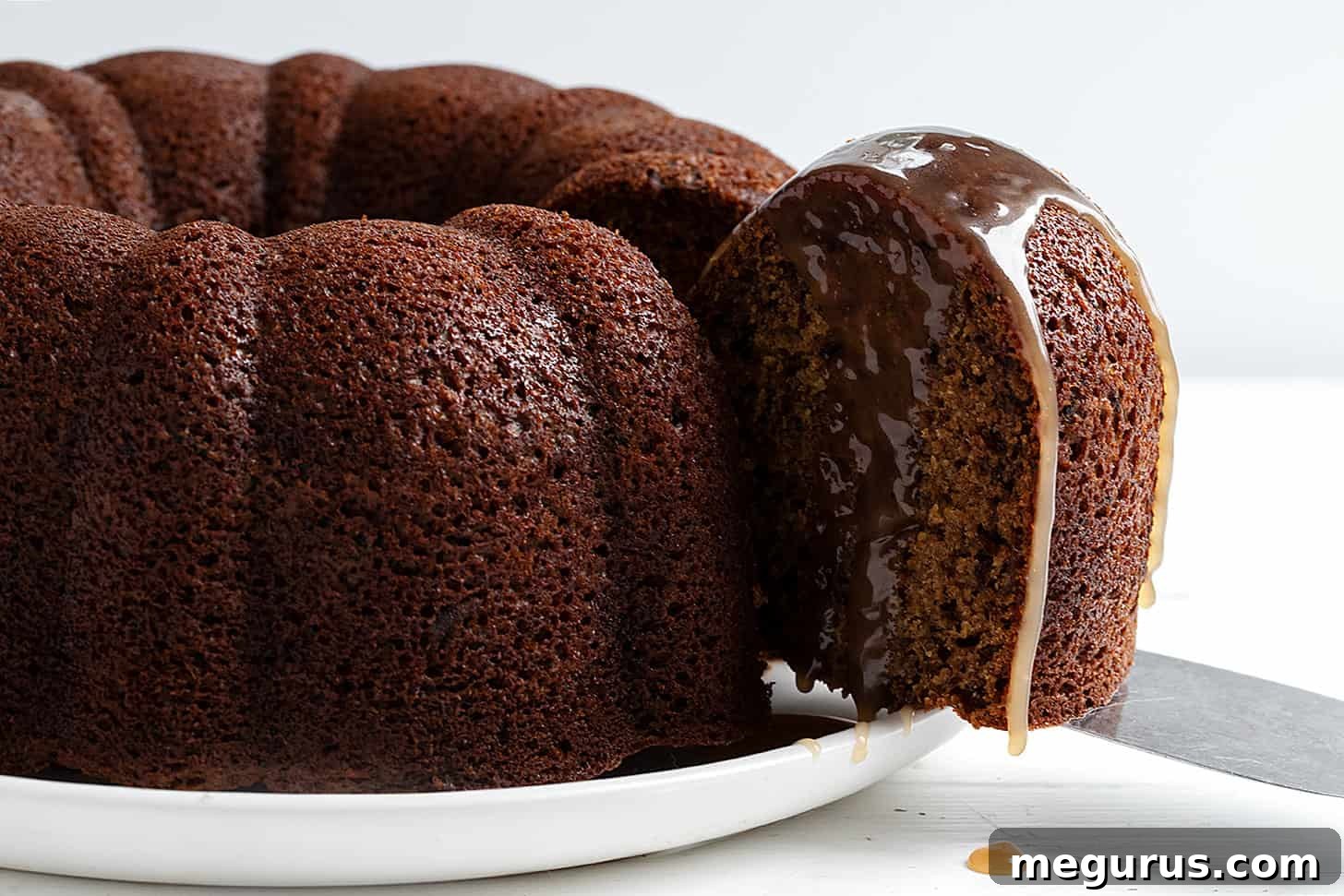 Classic Sticky Toffee Bundt Cake sliced on a plate, generously drizzled with warm toffee sauce