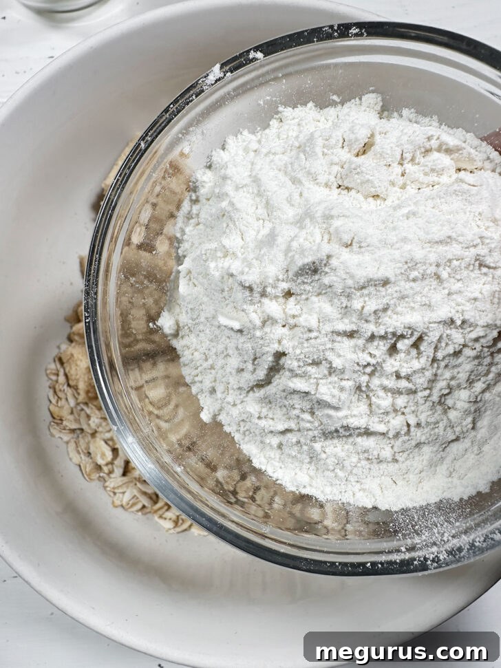 Mixing oats, flour, and brown sugar in a large bowl for the base and topping.