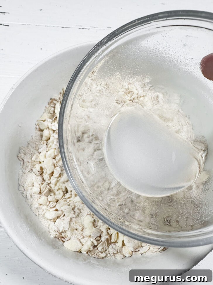 Drizzling dissolved baking soda mixture over the oat and butter crumb.
