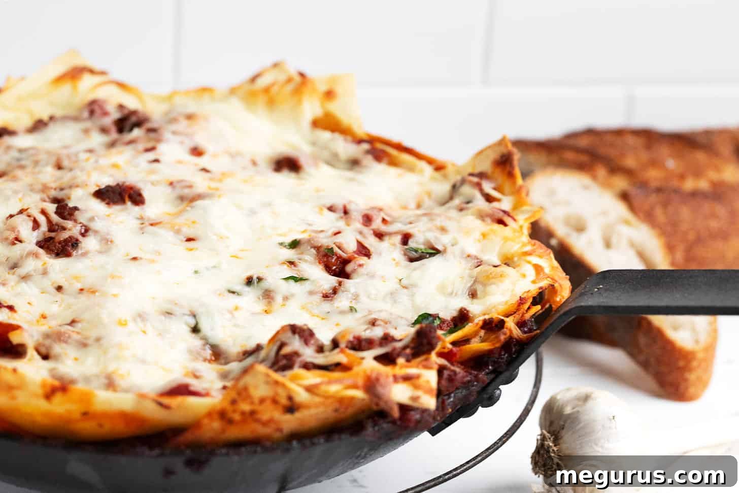 Close-up of a bubbling skillet lasagna made with fresh pasta sheets, ready to be served.