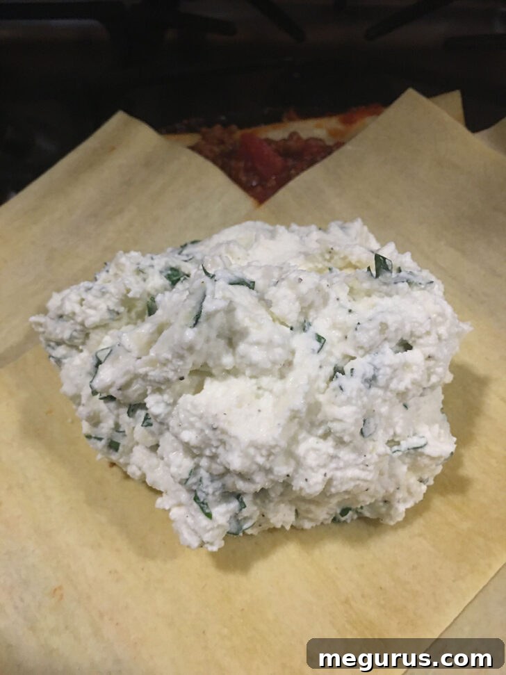Adding the creamy ricotta cheese mixture to the skillet lasagna.