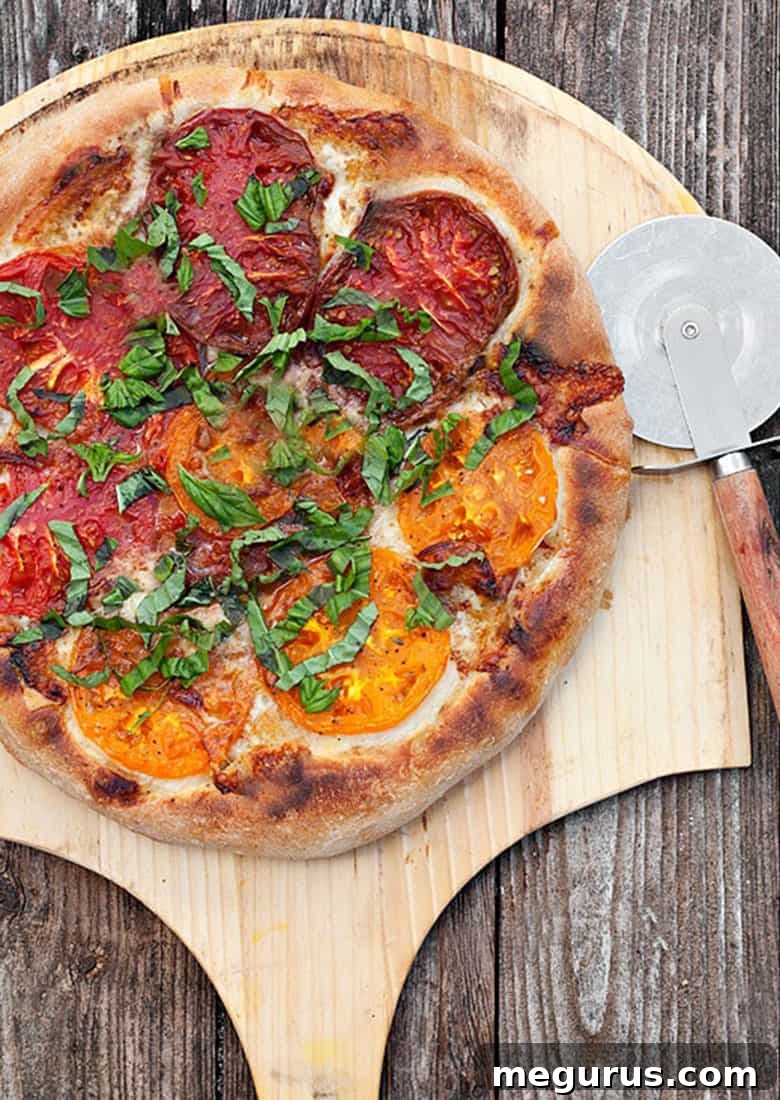 Vibrant close-up of fresh heirloom tomatoes and aromatic basil leaves, key ingredients for the summer pizza