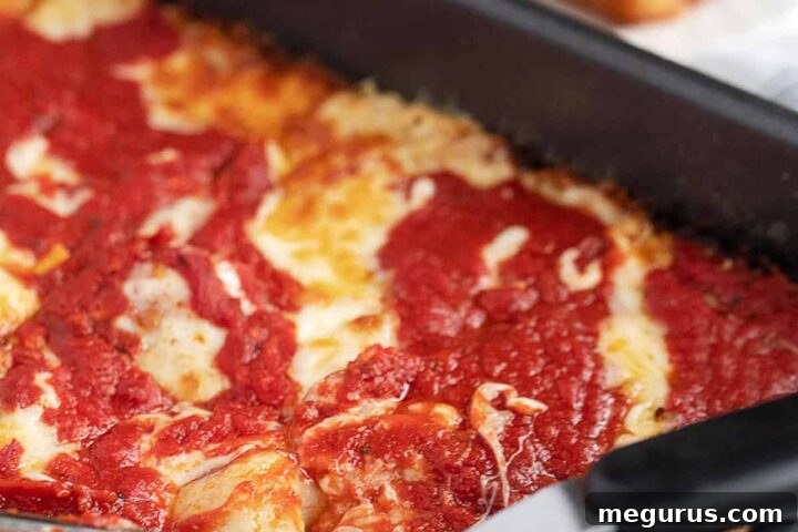 Detroit Style Pizza in pan, ready to be served, highlighting the crispy edges and rich toppings.