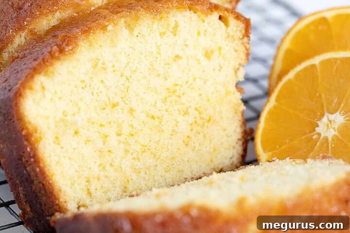Orange drizzle cake sliced on cooling rack