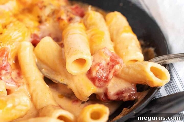 Pasta and cheese with tomatoes in a small cast iron pan, ready to serve