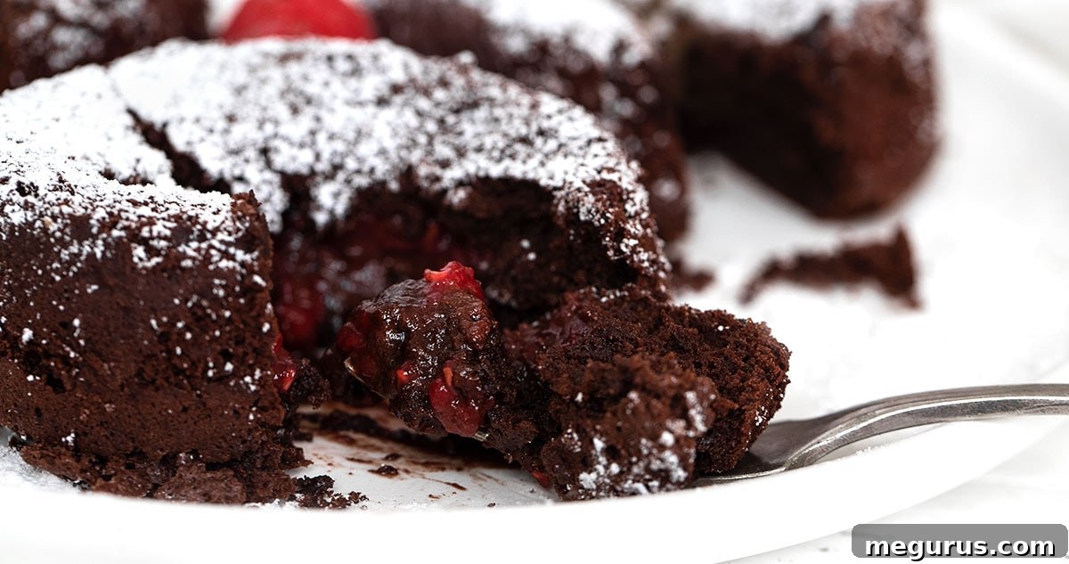 Irresistible chocolate molten cakes with a vibrant raspberry filling, elegantly presented on a plate with a fork, ready to be enjoyed.