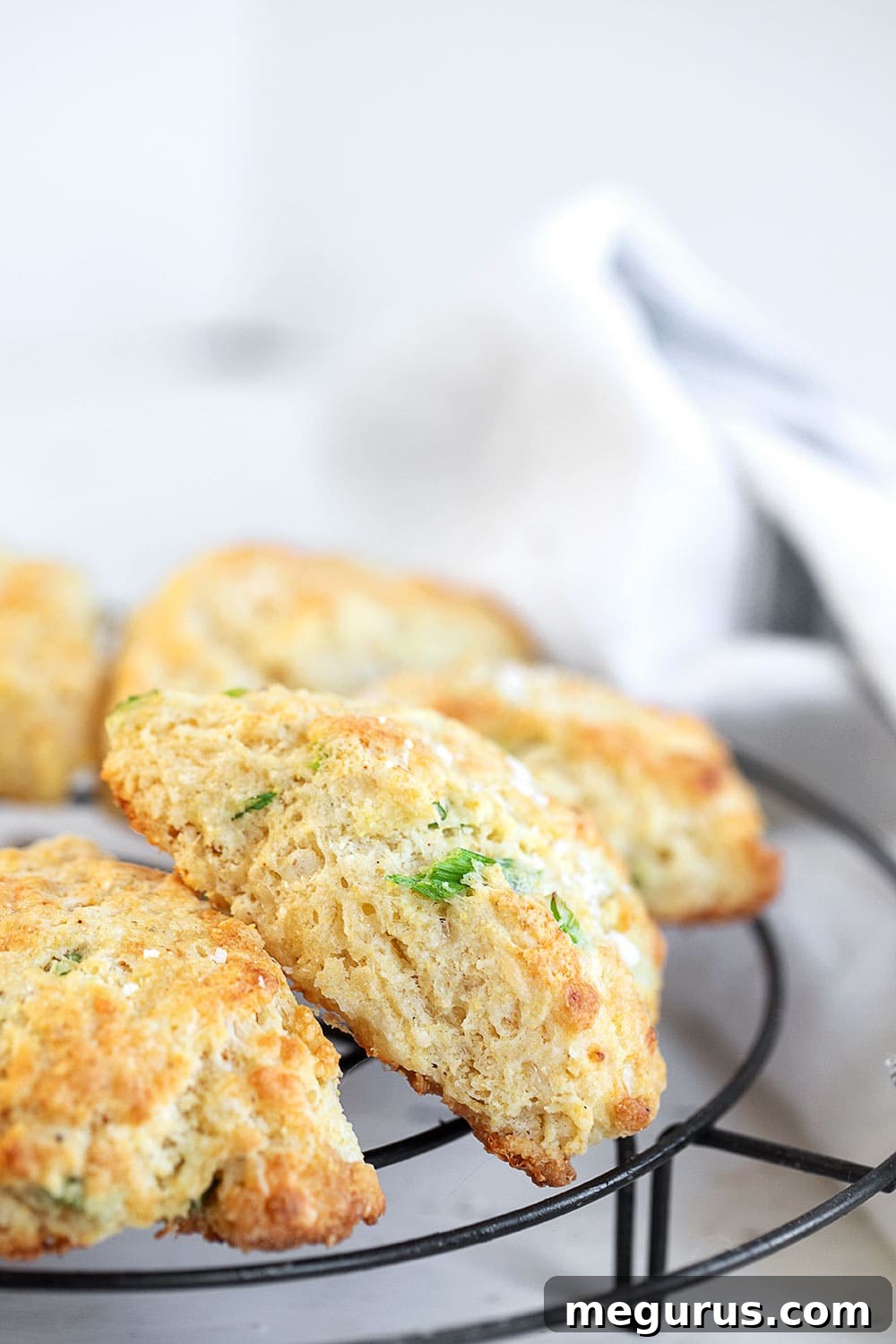 Freshly baked cornmeal cheddar biscuits cooling on a rack, ready to be served.