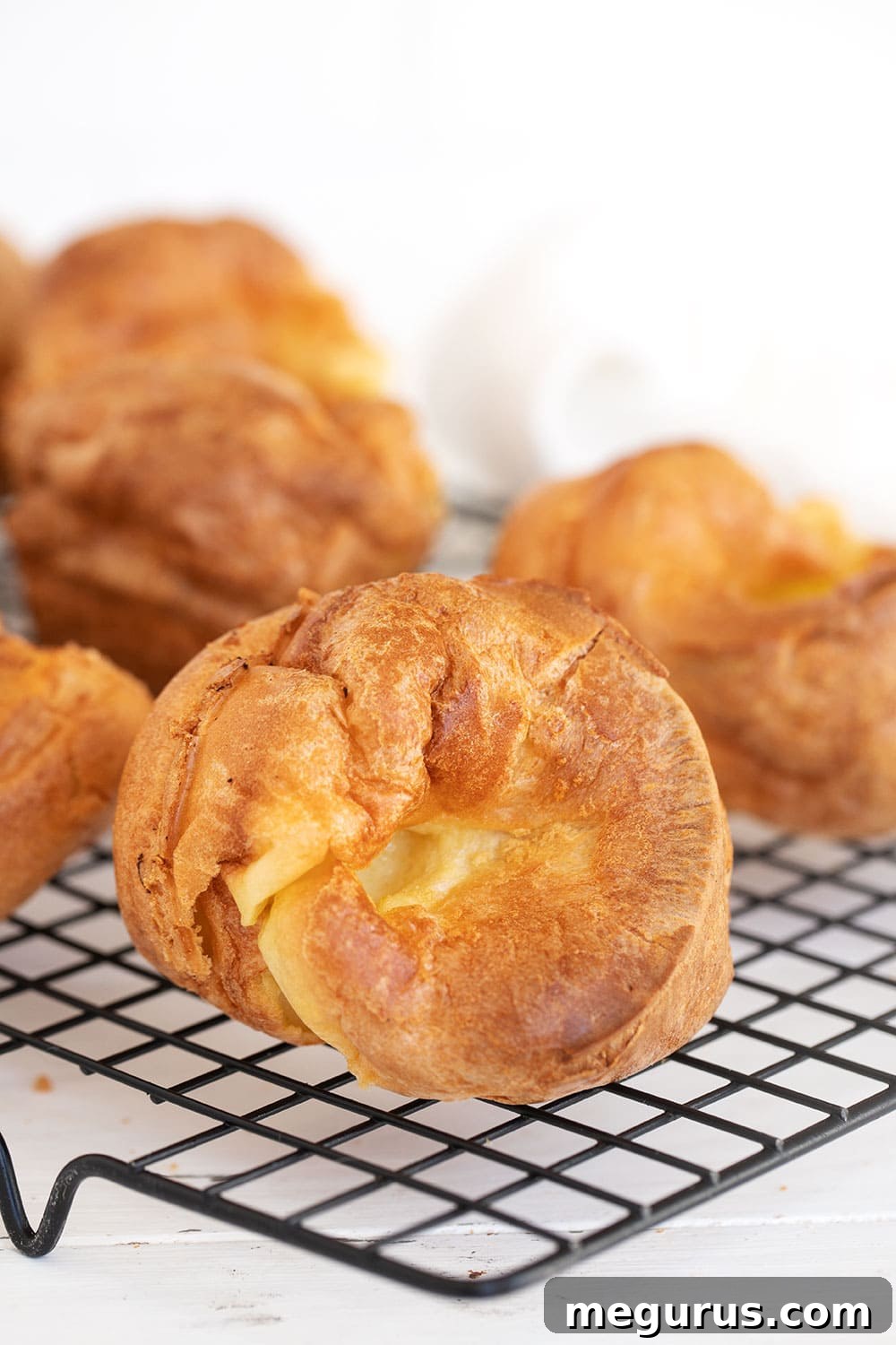 Golden brown Yorkshire Puddings cooling on a wire rack, ready to be served