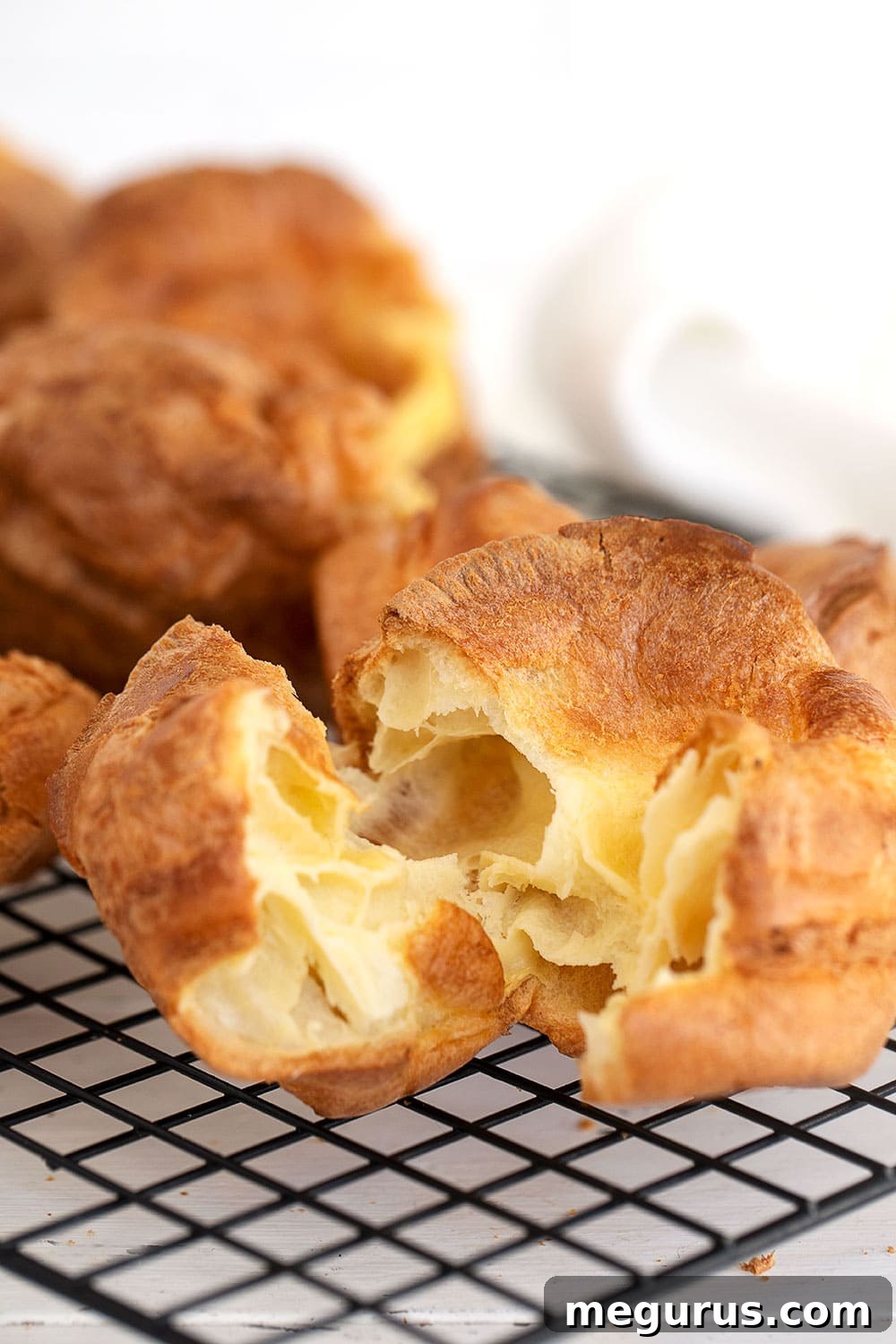 A close-up of a perfectly golden, hollow Yorkshire Pudding, ready for gravy
