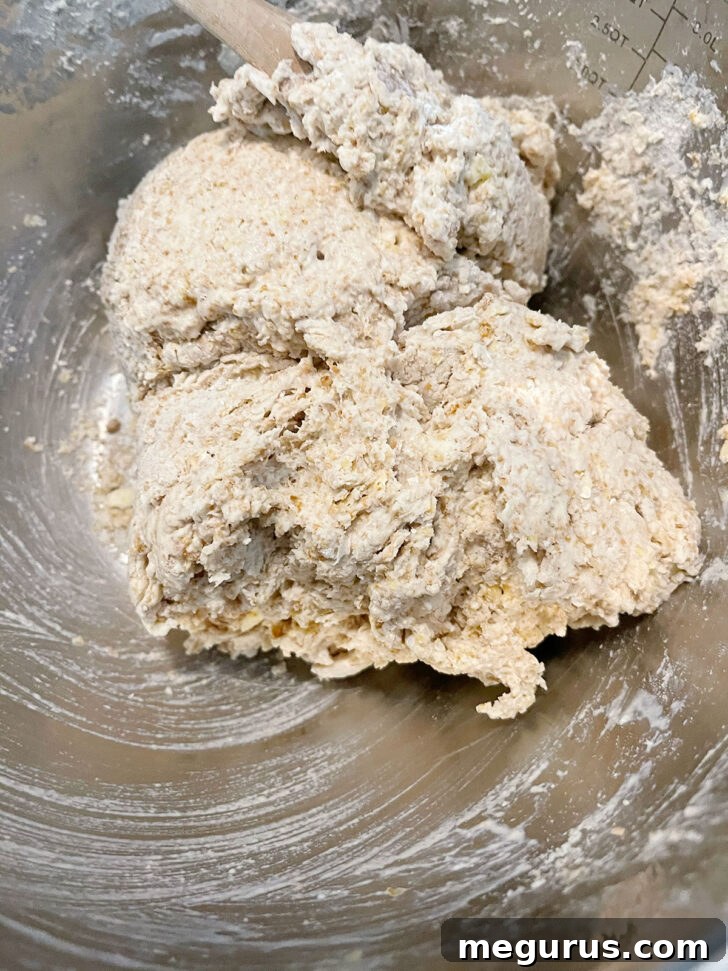 Stirring the brown soda bread dough together, forming a cohesive mixture.