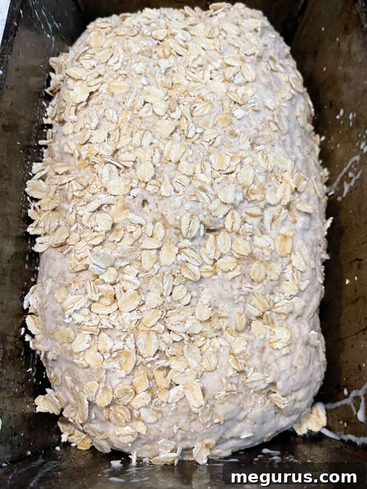 Pressing rolled oats onto the top of the loaf for a delightful crunch.