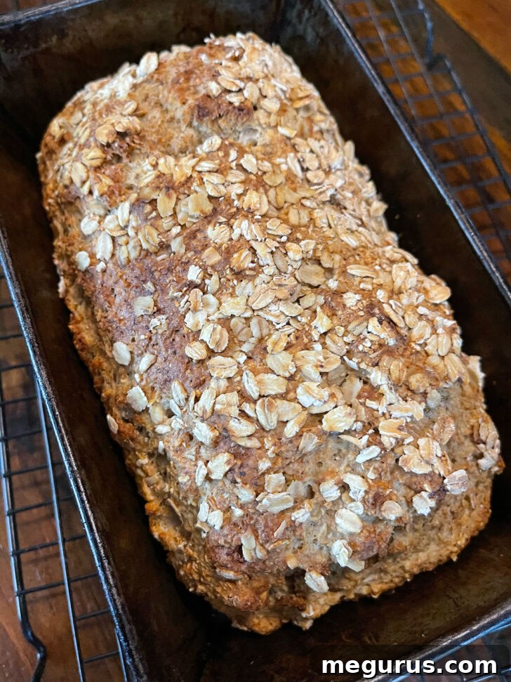 Freshly baked brown soda bread in a loaf pan, golden and inviting.