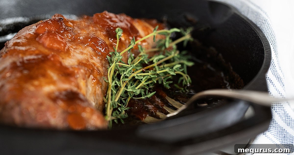 Delicious apricot mustard glazed pork tenderloin in a cast iron skillet, ready to serve.