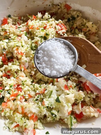 Adding pickling salt to the chopped vegetables.