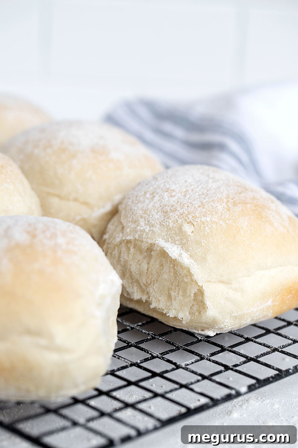 Close-up of freshly baked Irish blaa buns on a cooling rack, showing their characteristic floury top.