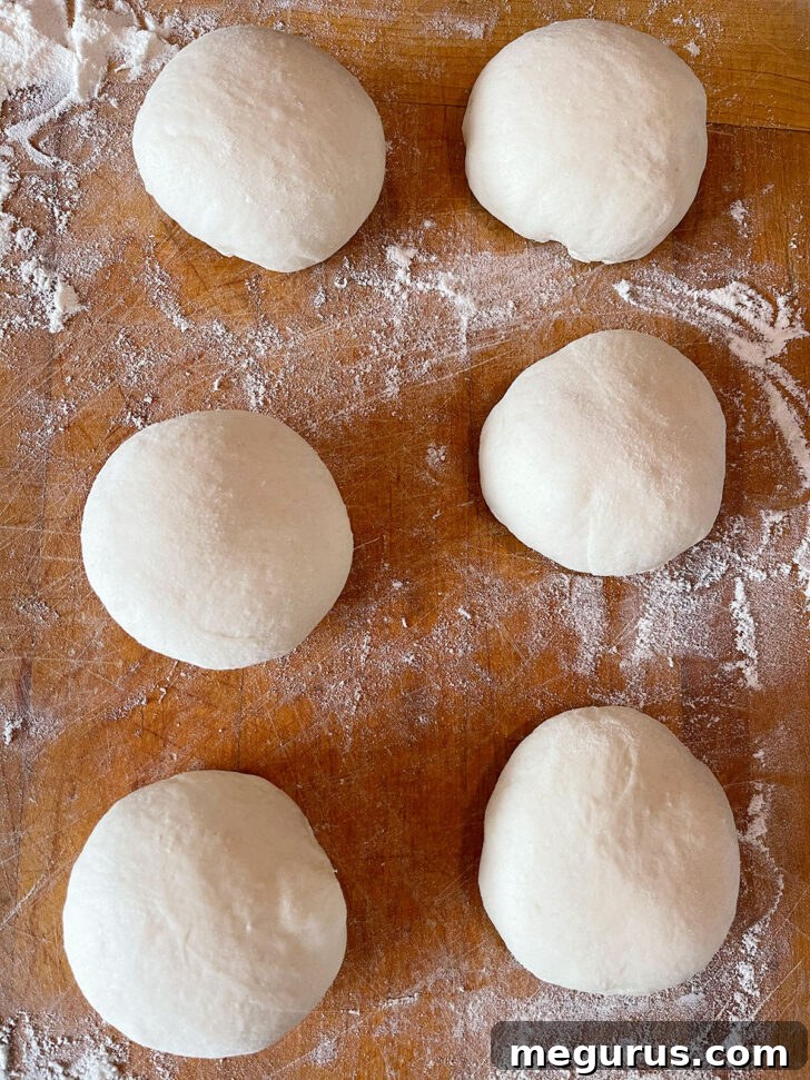 Forming the dough into smooth, slightly flattened balls.