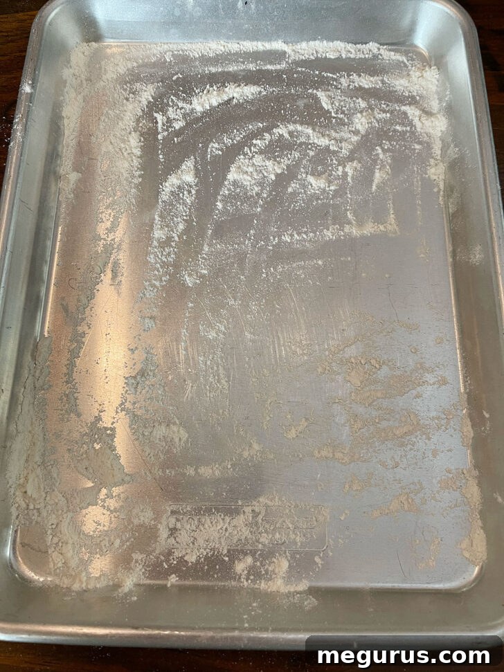 Adding a generous layer of flour to the baking pan.