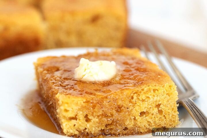 Old-Fashioned Johnny Cake with maple syrup and butter, presented on a plate.