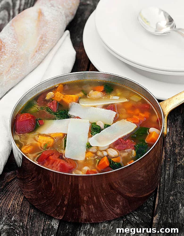 Harvest vegetable soup in a small copper saucepan, garnished with fresh herbs.