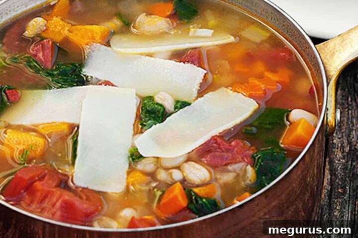 Hearty Harvest Vegetable Soup with white beans in a rustic copper pot.