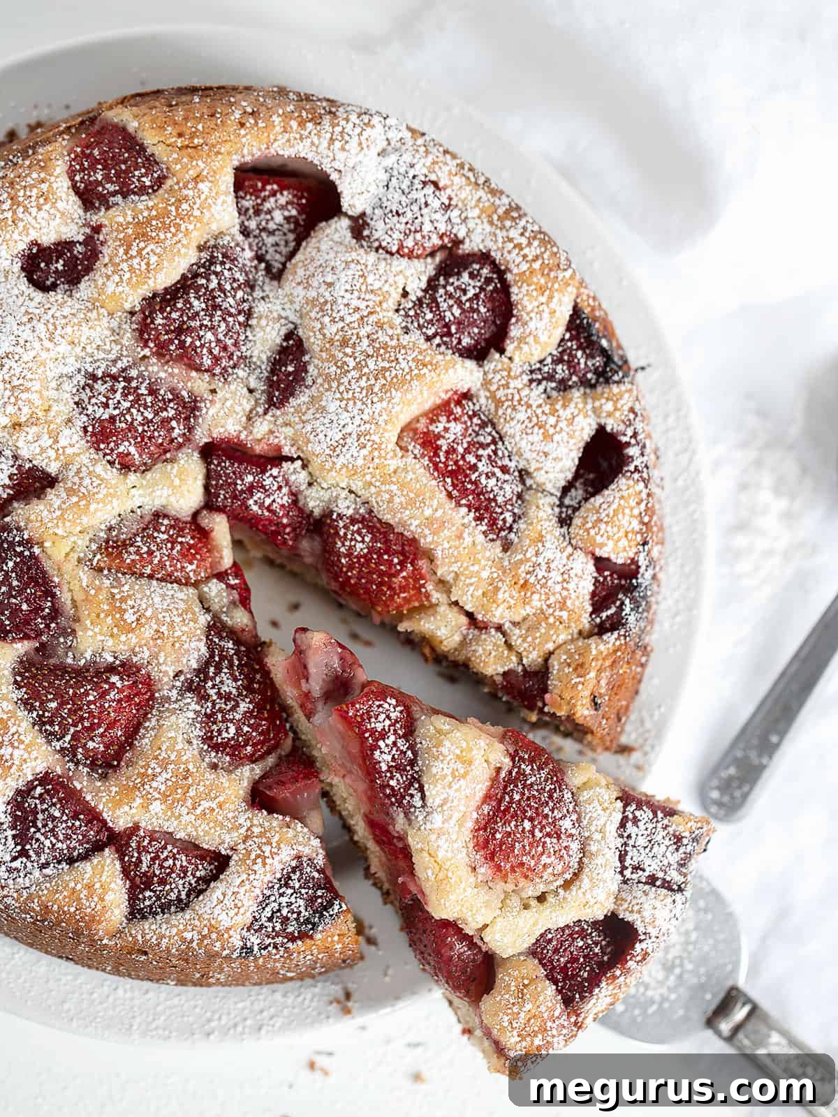 Overhead view of a strawberry yogurt cake, with some slices removed