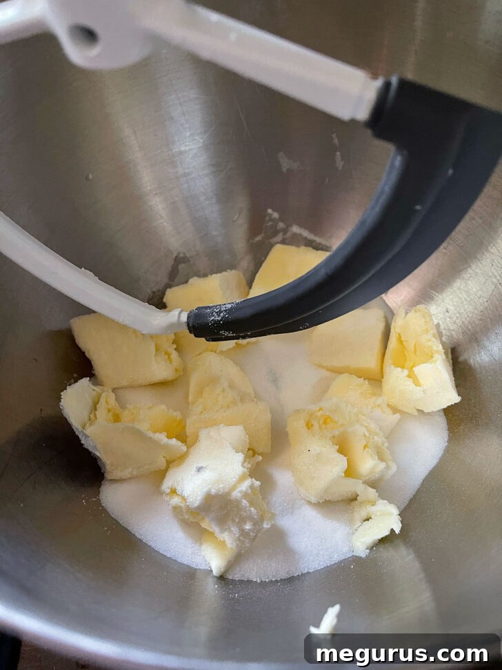 Butter and sugar being creamed in a stand mixer bowl