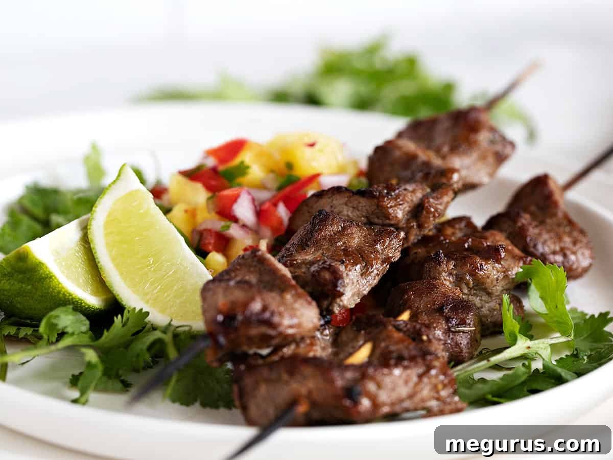 jerk pork skewers on plate with pineapple salsa