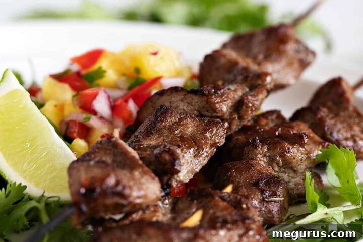 jerk pork skewers on plate with pineapple salsa