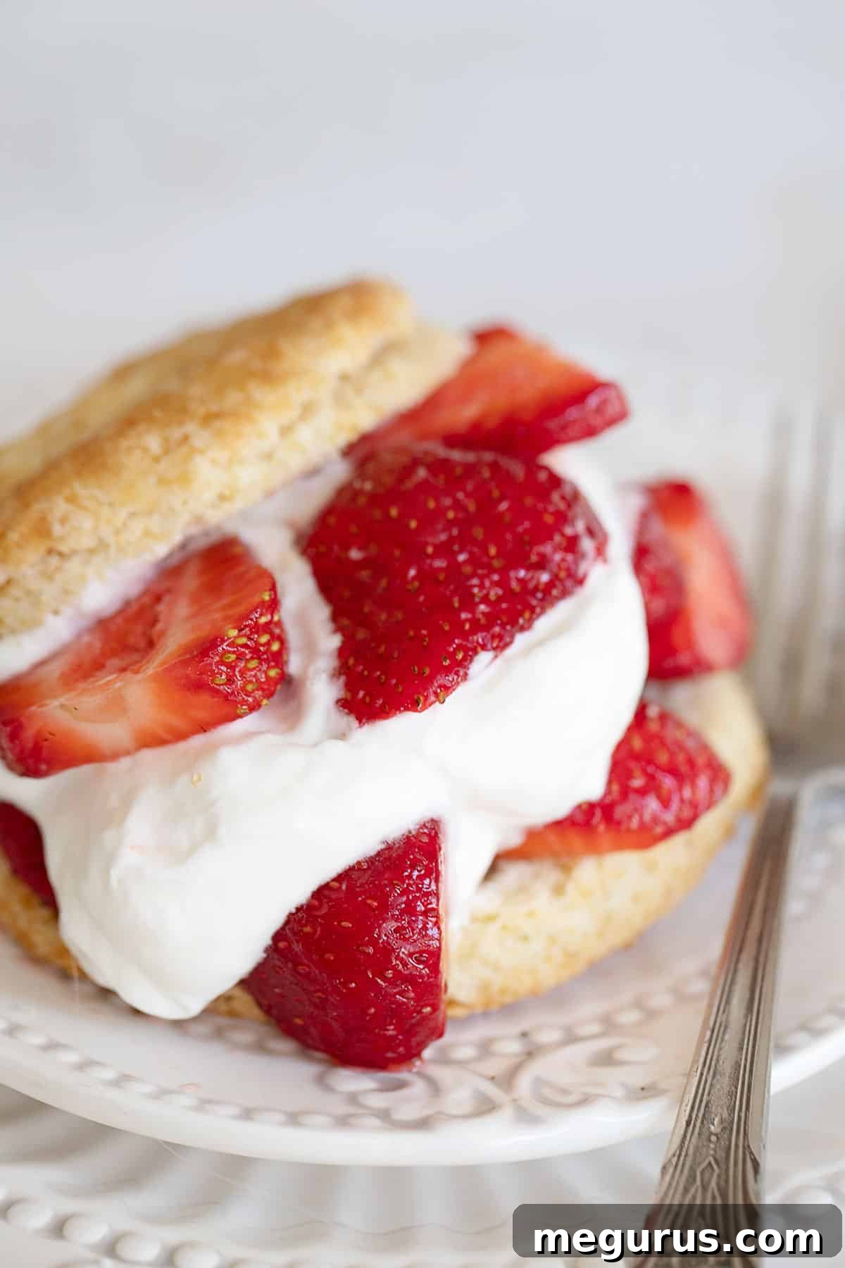 Old-fashioned strawberry shortcake with a fork, ready to be enjoyed.